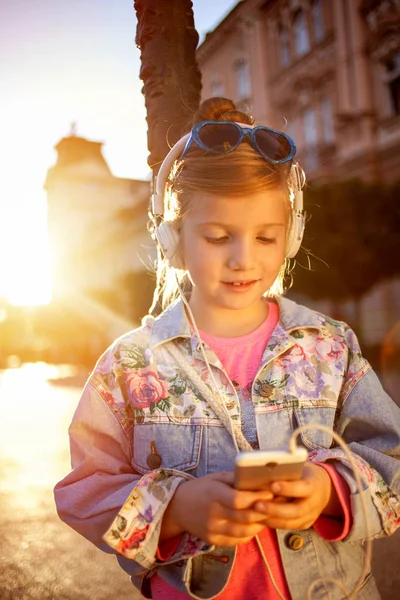 Chica bastante joven escuchando música con sus auriculares en la st — Foto de Stock