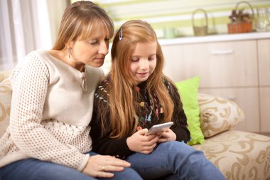 Aile ve teknoloji, kadın ve yetişkin kızı smartp kullanarak