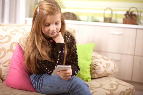 Pequena menina caucasiana texto seus amigos na rede social — Fotografia de Stock