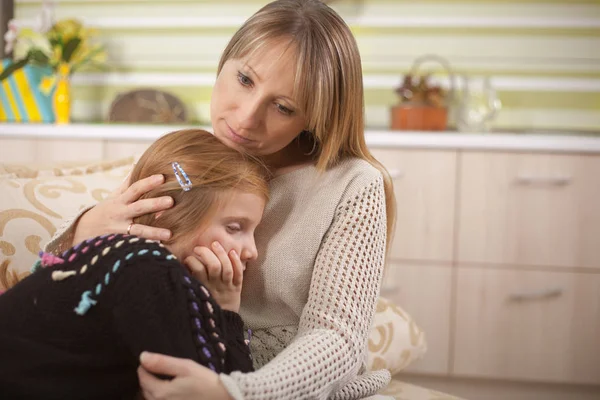 Jonge moeder is haar triest dochter troostend — Stockfoto