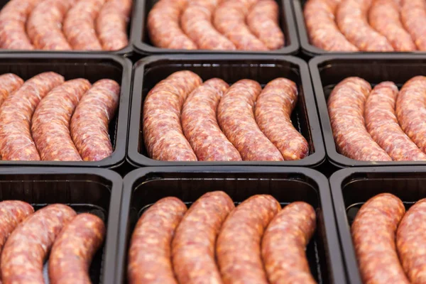 Raw meat sausages in packing box