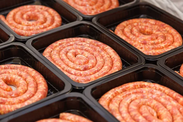 Rolled raw meat sausages in packing box