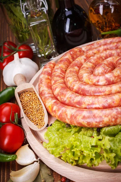 Pork sausage along vegetables and spices — Stock Photo, Image