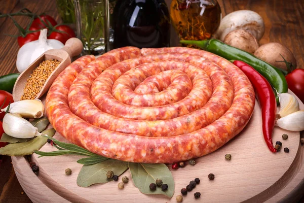 Pork sausage along vegetables and spices — Stock Photo, Image