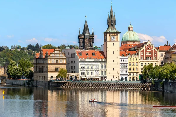 Vista del reloj de la iglesia en Praga con el río Moldava en fron — Foto de Stock