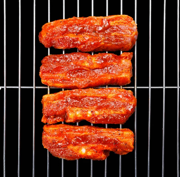 Marinated belly slices on barbecue grid — Stock Photo, Image