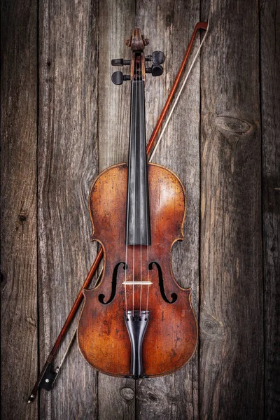 Скрипка с луком на деревянном фоне — стоковое фото