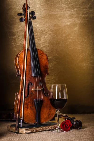 Vino tinto en vaso y violín viejo — Foto de Stock