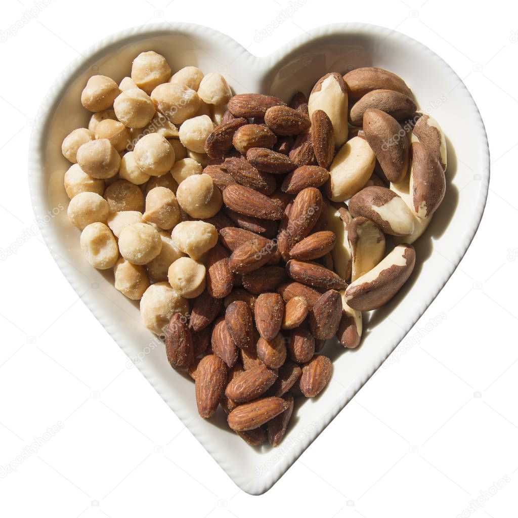 An assortment of roasted and salted Macadamia Nuts, Almonds and Fresh Brazil Nuts served in a heart shaped plate