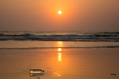 Goa, Hindistan 'da bir plaja atılmış plastik bir su şişesi.