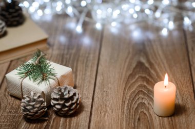 Noel süslemeleri ile bir tabloda yanan mum