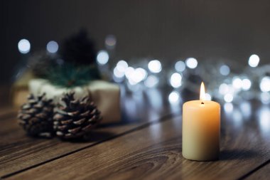 Noel süslemeleri ile bir tabloda yanan mum