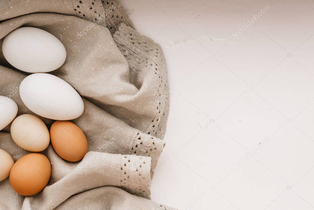 Chicken eggs on the linen napkin on a table.