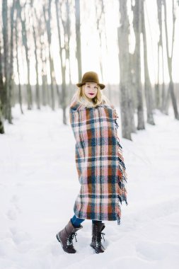 bir battaniyeye sarılmış şapkalı kız