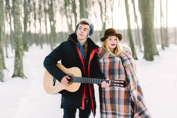 Un homme avec une guitare, tenant la main avec sa petite amie moment sensuel atmosphérique. Couple hipster élégant dans un look branché. concept de mariage rustique — Photo