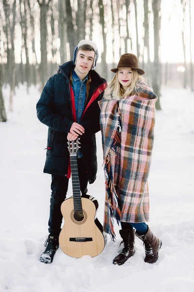 Un homme avec une guitare, tenant la main avec sa petite amie moment sensuel atmosphérique. Couple hipster élégant dans un look branché. concept de mariage rustique — Photo