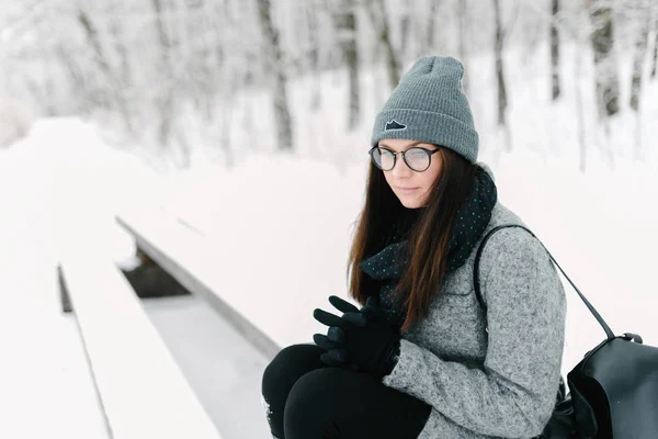 Retrato de una morena con gafas y un abrigo gris — Foto de Stock