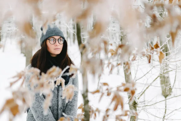 Gözlük ve gri bir ceket giyen bir esmer portresi
