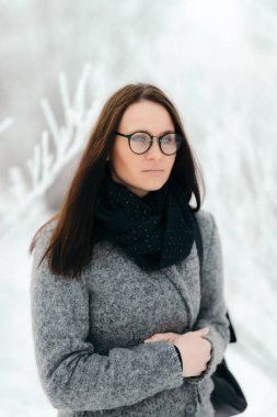 Gözlük ve gri bir ceket giyen bir esmer portresi