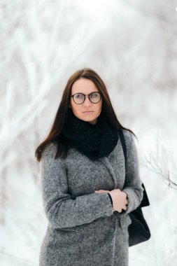 Gözlük ve gri bir ceket giyen bir esmer portresi