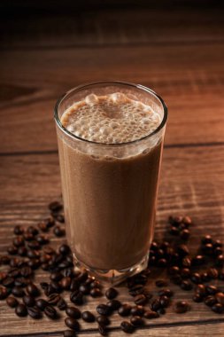 Ahşap arka plan üzerinde bir bardak kahve ve muz smoothie