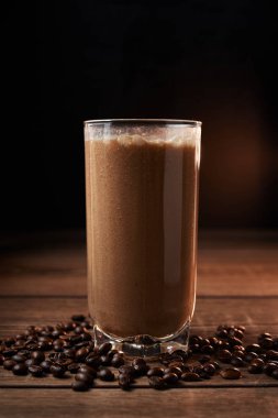 Ahşap arka plan üzerinde bir bardak kahve ve muz smoothie