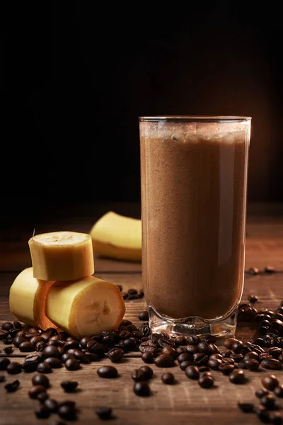Кофе и банановый коктейль в стакане на деревянном фоне — стоковое фото
