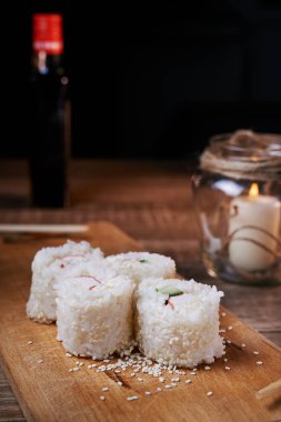 Japon yemekleri, suşi rulo ile Yengeç, susam, salatalık, peynir, ahşap oyun tahtası