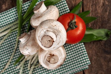 Mantar, domates, yeşillik bir peçete üzerinde