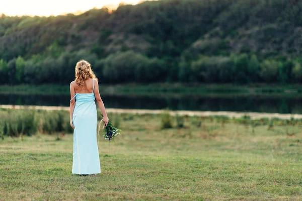 Menina encaracolado luz em um vestido azul, fotosessão na primavera sobre a natureza — Fotografia de Stock