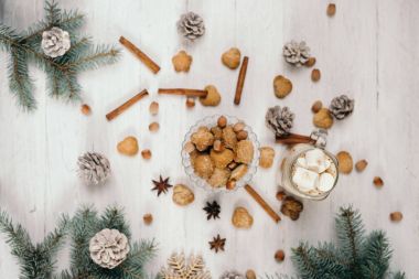 Sütlü kahve. Bisküvi, tarçın, yıldız anason ve Noel şube koniler, bir beyaz tahta masanın üzerinde yatan ile Ladin