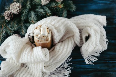 Yeni yıl kapuçino marshmallow, eski mavi ahşap masa, Dekorasyon, çam kozalakları ile bir dal için için atkı örgü beyaz ile