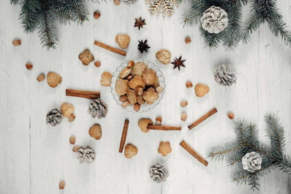 Koffie met melk. Koekjes, kaneel, steranijs en Kerstmis branch sparren met kegels, liggend op een witte houten tafel — Stockfoto