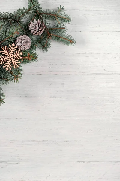 Σε ένα φόντο λευκό ξύλινο χριστουγεννιάτικο δέντρο και κώνους Φωτογραφία Αρχείου