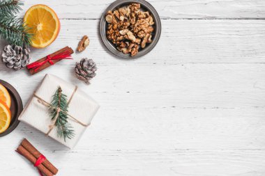 Kes, tarçın, ceviz beyaz bir arka planda turuncu. Dalları Noel ağaçları, hediyeler ve çarpmak. Düz bir yere kopyalamak için bir üst görünümden bir yer. Tatil.