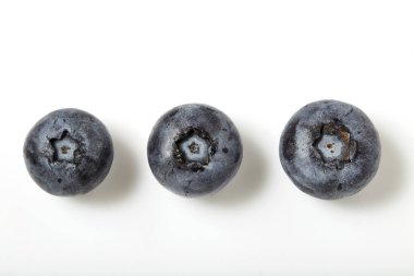 beyaz zemin üzerinde üç yaban mersini makro