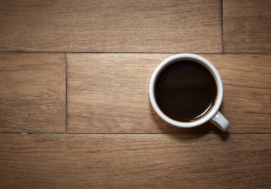 Ahşap masa arka plan boşluk ile üzerinde kahve fincanı Üstten Görünüm