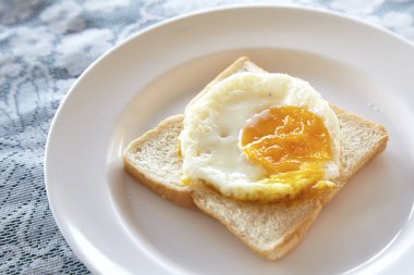 Kızarmış yumurta ekmek kahvaltı tabağı ve rustik masa