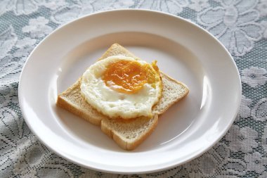 Kızarmış yumurta ekmek kahvaltı tabağı ve rustik masa