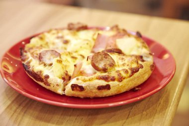 Restoranda ahşap bir masada pizza..