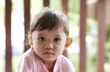 küçük kız gülümseyerek Asya üzerinde yeşil arka