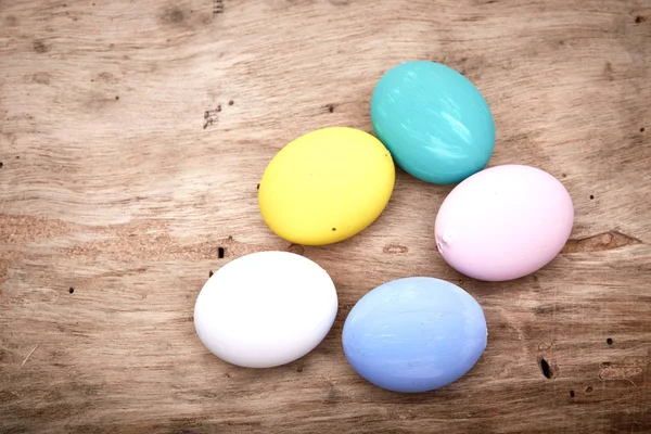 easter, holidays, tradition and object concept - colored easter eggs on wooden surface