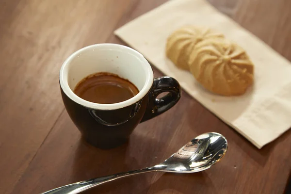 Café noir est mangé avec un cookie — Photo