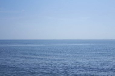 Dalgalar mavi deniz ve gökyüzü gökyüzünde havadar bulut ile