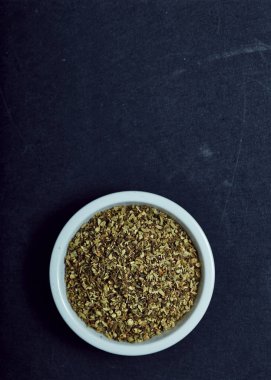 Kurutulmuş kekik otlar siyah arka plan üzerine beyaz kase