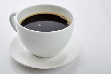 Beyaz arka planda kahve fincanı ve çay tabağı.