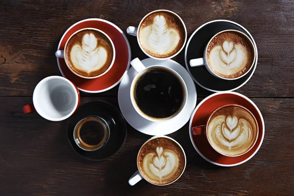 Viele Tassen Kaffee auf Holztisch, Draufsicht — Stockfoto