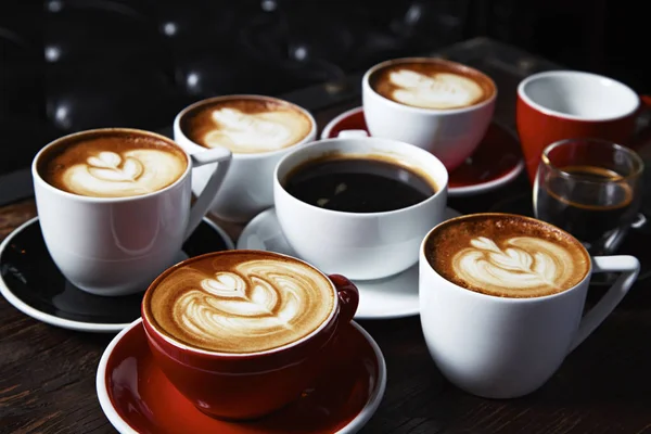 Mnoho šálků kávy na dřevěném stole, pohled shora — Stock fotografie