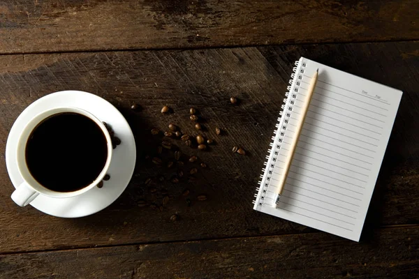 Κάτοψη του μαύρου καφέ και κενό σημειωματάριο — Φωτογραφία Αρχείου