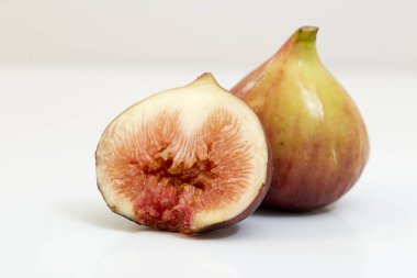 Beyaz arka planda dilimlenmiş taze incirler.